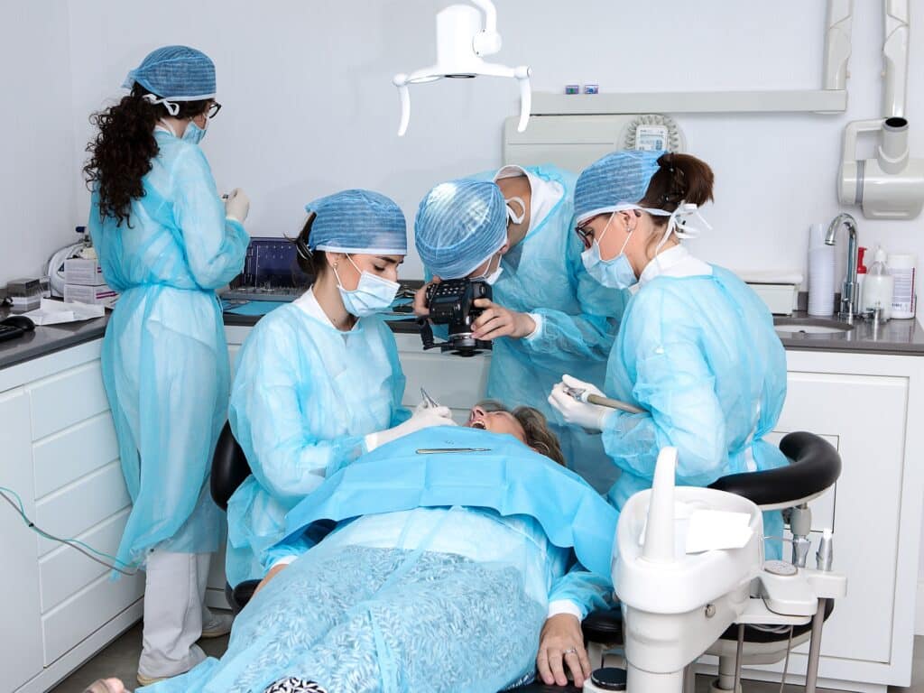 Dentist performing teeth surgery on patient